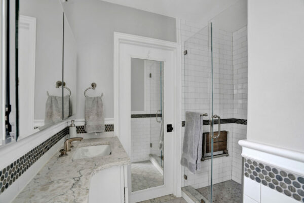 Walk-in shower installation with bench and multiple shower heads in Irvine bathroom